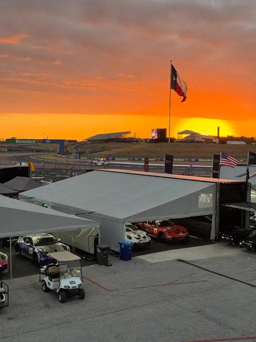 Sunset over the COTA paddock with the Texas flag and team tents